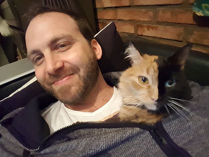 a man with a cat in his lap